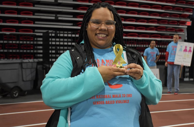 A participant poses for a photo at Safe Passage's annual Walk A Mile in Their Shoes event on April 18, 2026, at the Northern Illinois University Convocation Center in DeKalb. The event, held to raise awareness of sexual violence and supoprt survivors, was hosted by the nonprofit as part of Sexual Assault Awareness Month.