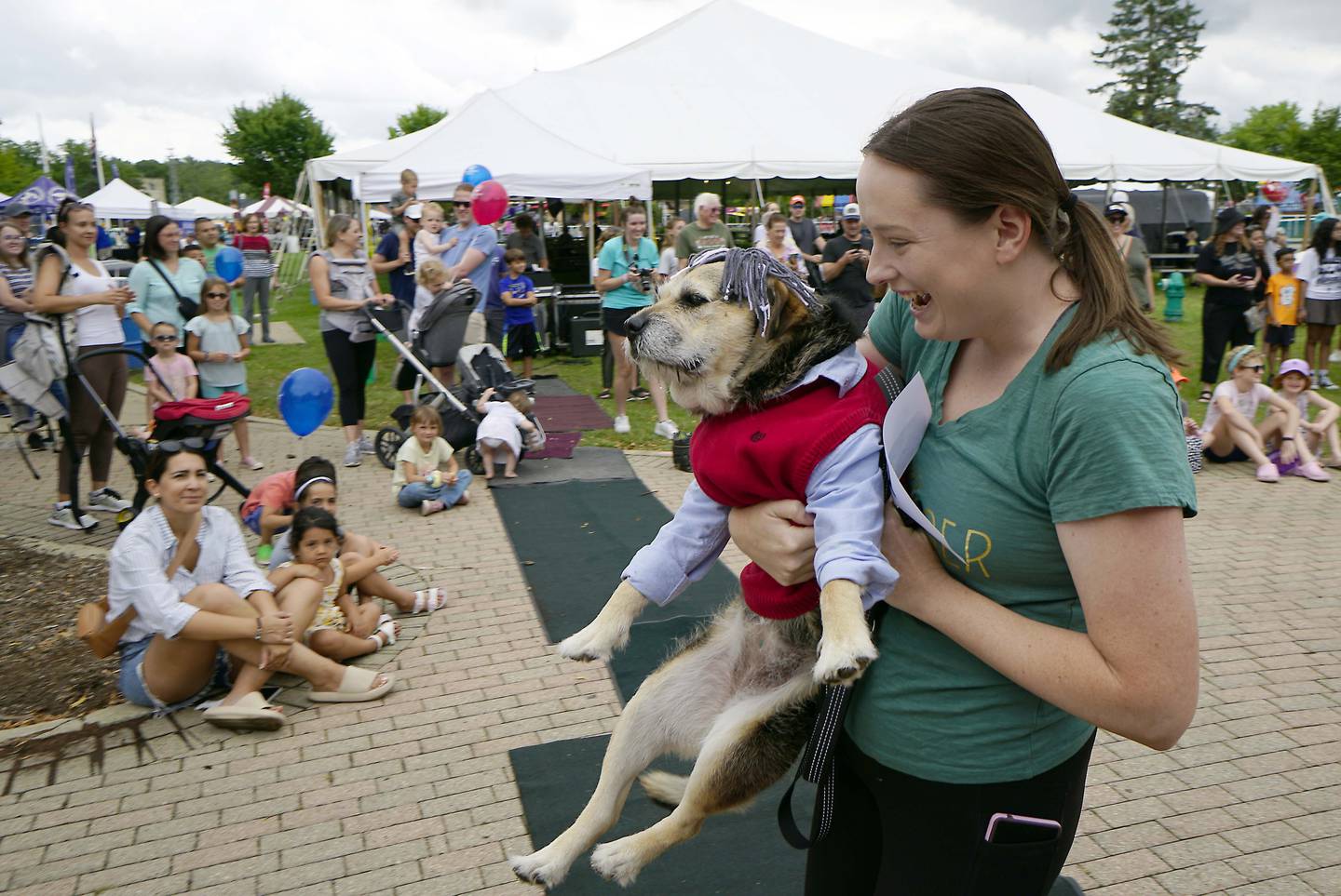 Jackie Rakers of Batavia carries her dog Heaven who is dressed as Batavia Mayor Jeffery Schielke off the stage during the pet competition during the Windmill City Festival Saturday July 8, 2023 in Batavia.