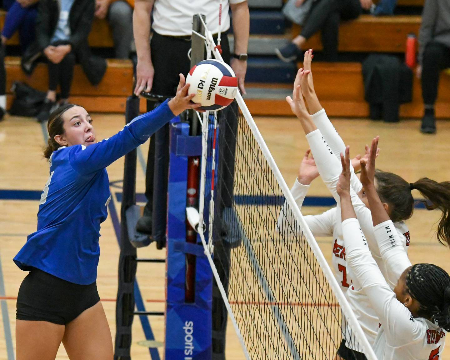 St. Charles North's Haley Burgdorf ,left, tries to get the ball over the net but gets blocked by Benet Academy's Audrey Asleson, center and Brooklynne Brass during the 4A sectional championship game on Thursday Nov. 7, 2024, held at West Aurora High School.