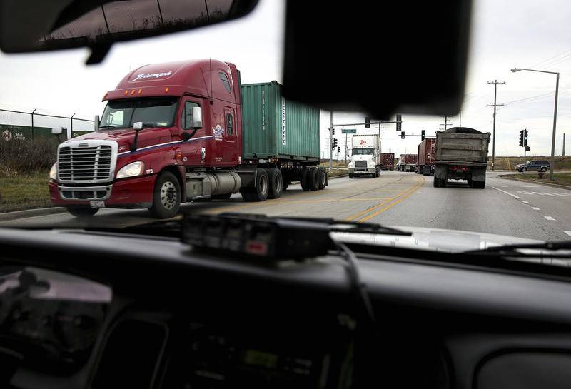 Lines of trucks and semi-trailers slowly drive along Laraway Road Thursday, Dec. 10, in Joliet.