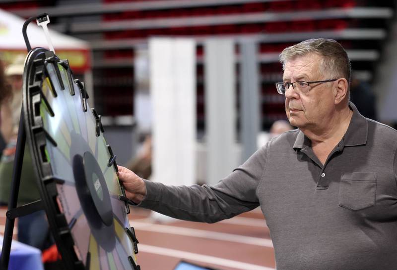 Al Diestelkamp, from Cortland, spins the prize wheel at one of the booths Thursday, April 24, 2025, during the Local Showcase and Spring Show in the Convocation Center at Northern Illinois University in DeKalb.