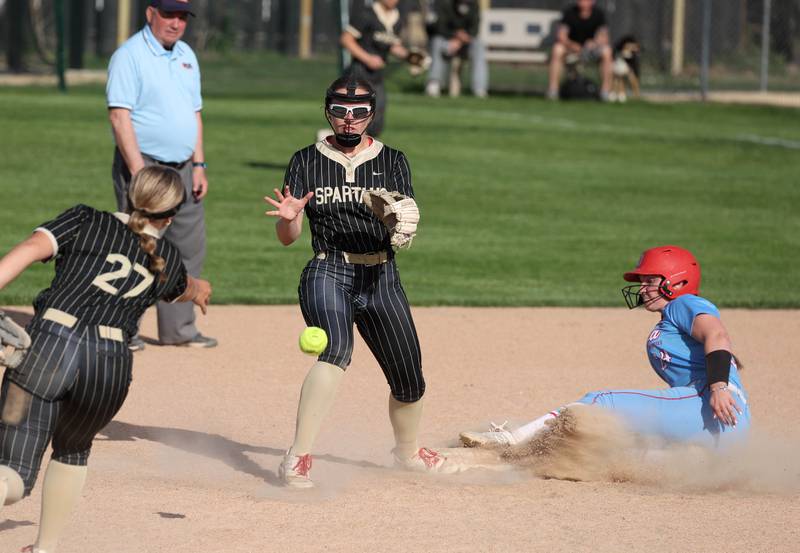 Sycamore's Addison Armstrong flips the ball late to Brighton Snodgrass as Ottawa's Bobbi Snook slides in safely Monday, May 12, 2025, during their game at Sycamore High School.
