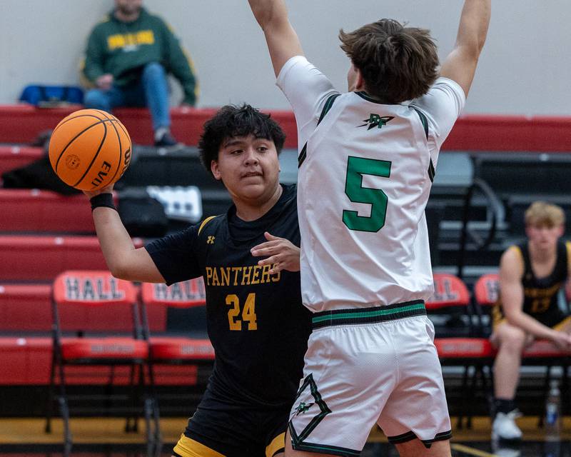 Alan Castro (24) of Putnam County passes ball around Ethan Moeller (5) of Rock Falls during game in the Colmone Classic on Monday, December 8, 2025 at Hall High School in Spring Valley.