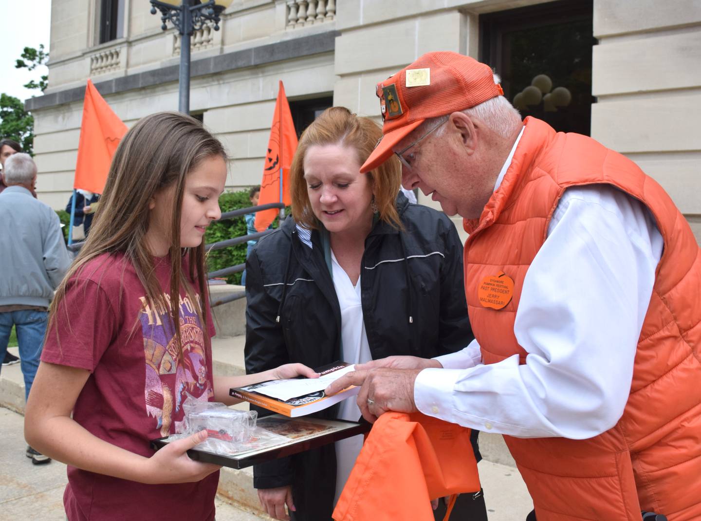 On Wednesday, May 18, 2022, Vivian Rubicz, an 11-year-old fifth grader from St. Mary’s School Sycamore, received an award an other items for winning the Sycamore Pumpkin Festival's theme contest. From left, theme contest winner Vivian Rubicz, Pumpkin Fest’s theme committee chair Jennifer Diehl, and festival historian Jerry Malmassari.