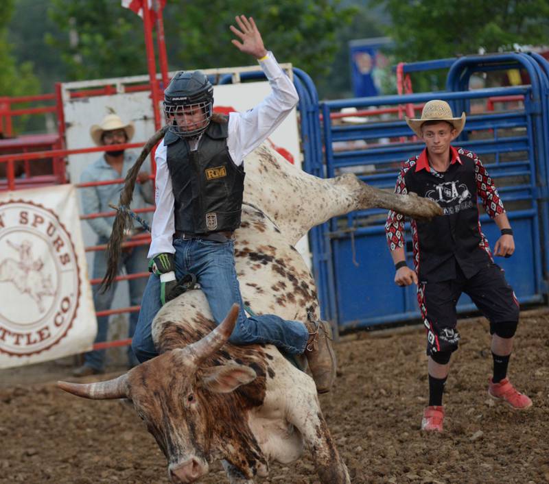 Tyler Williams tries to stay on Bojangles during the bull riding event at the T & A Bucking Bulls Rodeo at the Ogle County Fair on Friday, Aug. 1, 2025 in Oregon.