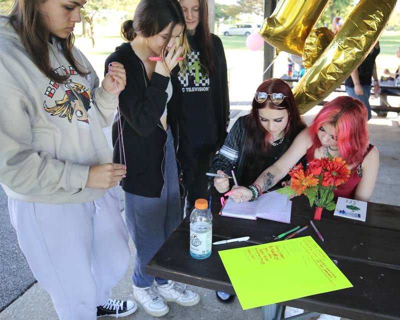 Attendees sign a guest book and a petition for Gracie’s Law asking for harsher penalties for sex offenders Friday, Sept 15, 2023, at the Sycamore Community Sports Complex during a celebration of the life of Gracie Sasso-Cleveland on what would have been her sweet 16 birthday. Sasso-Cleveland, 15, was found dead May 7, 2023, in DeKalb. Timothy M. Doll, 29, of DeKalb, is charged with first-degree murder in her death.