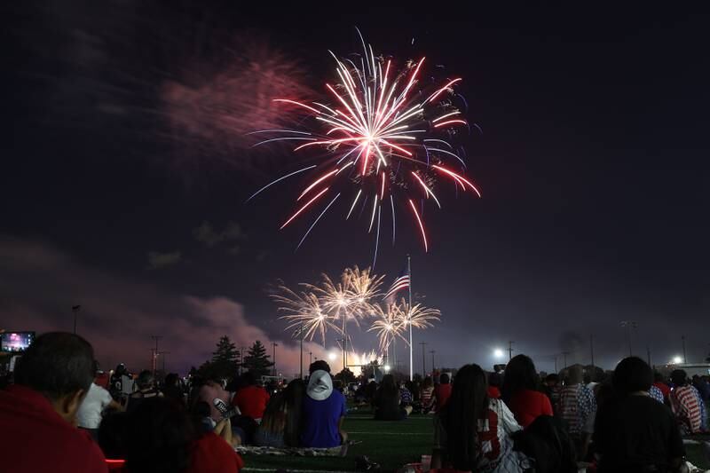 People watch the firework display from the field at Joliet Memorial Stadium in on Thursday July 4, 2024.