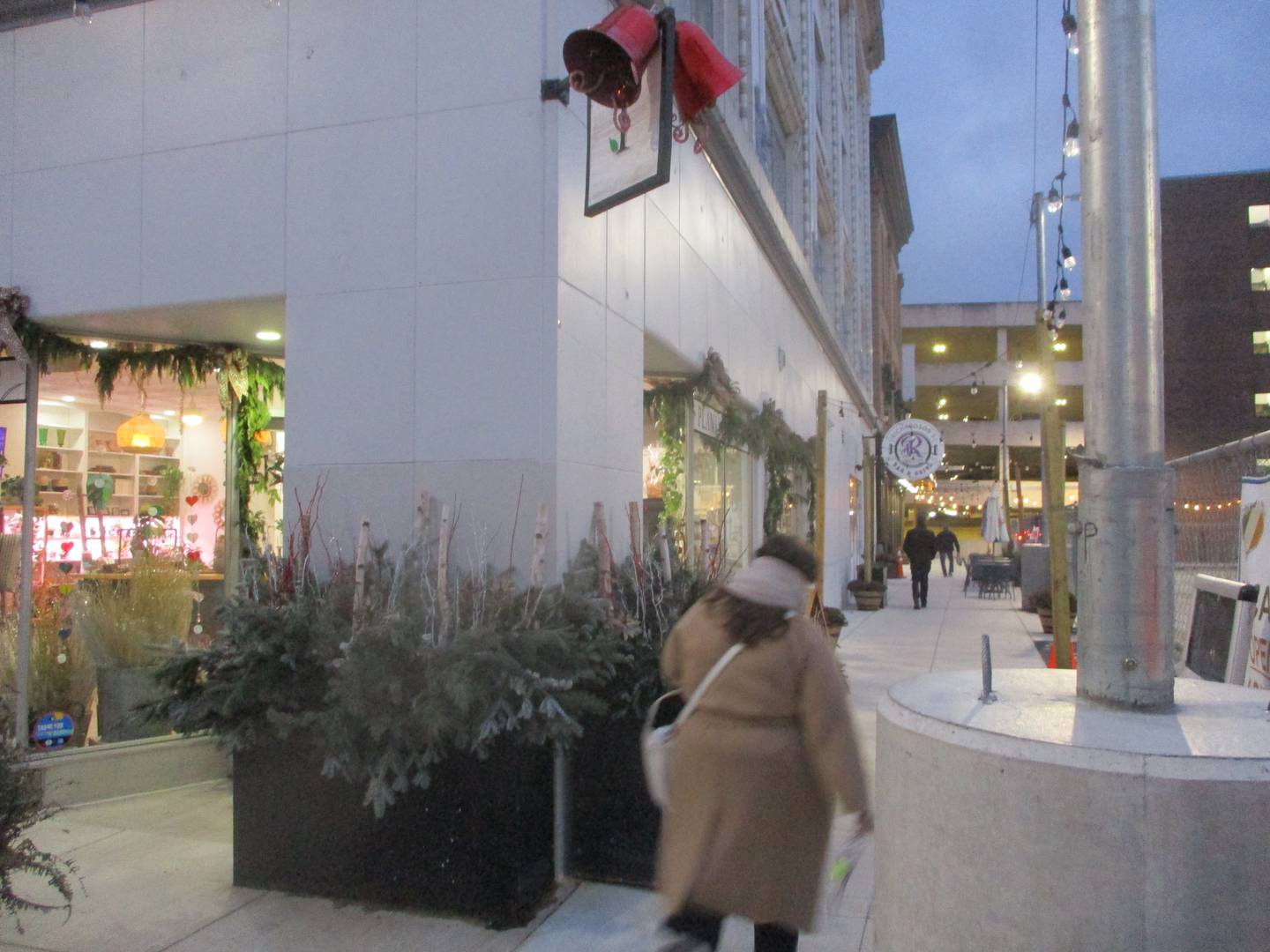 Pedestrians go past the Internode Greenery & Home store, which is decorated for the holidays, on their way to the Ottawa Street parking deck in downtown Joliet. Dec. 18, 2024