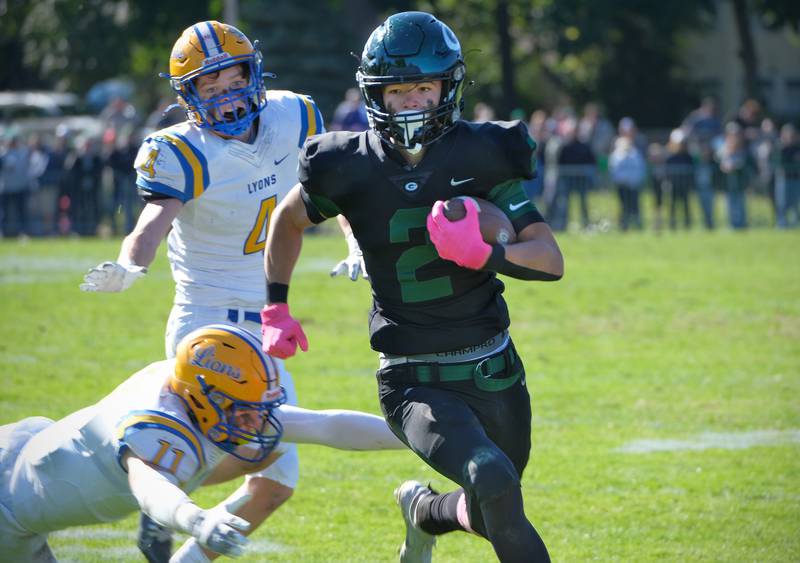 Glenbard West's Joey Pope (2) races past Lyons Township defenders Noah Pfafflin (11) and Quinn Farnan (4) after catching a pass during a game on Oct. 15, 2022 at Glenbard West High School in Glen Ellyn.