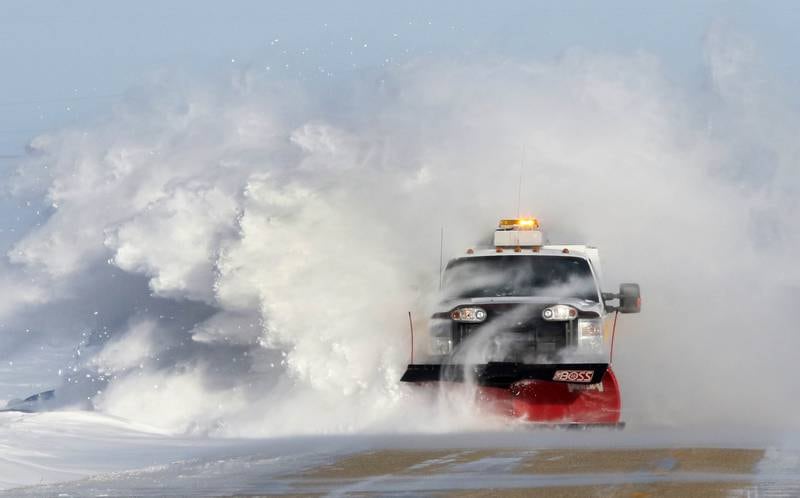 A DeKalb County snowplow takes out some of the snow drifts on Somonauk Road near Hinckley Wednesday. Snow continues to blow across roadways in open areas causing poor visibility and drifts in the road.