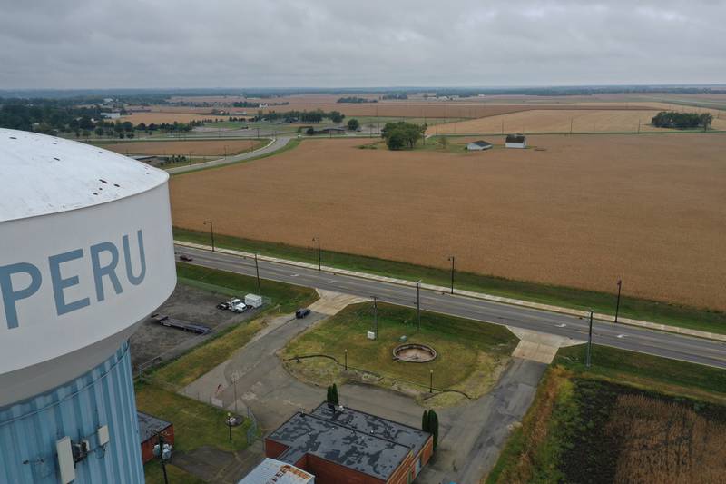 An aerial view looking west of the Peru water tower of a farm field near the intersection of Midtown Road and Peoria Street on Tuesday, Sept. 24, 2024 in Peru. The City of Peru released a drawing at the past city council meeting to give residents an idea of how a multi-faceted sports complex and city center may be laid out in Peru.