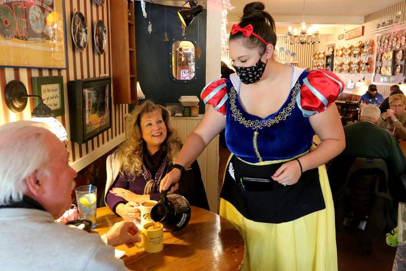 Windhill Pancake Parlor server Jennifer Brennan, dressed in costume as Snow White, fills the coffee cups of regular customers Edward and Karen Gabes of Grayslake on Halloween, Saturday, Oct. 31, 2020 in McHenry.  The couple has been going to the restaurant for years, citing the good food and friendly staff. "It's nice to see someone backing up the business in town and helping them out, keeping them open," Edward said of McHenry Mayor Wayne Jett.