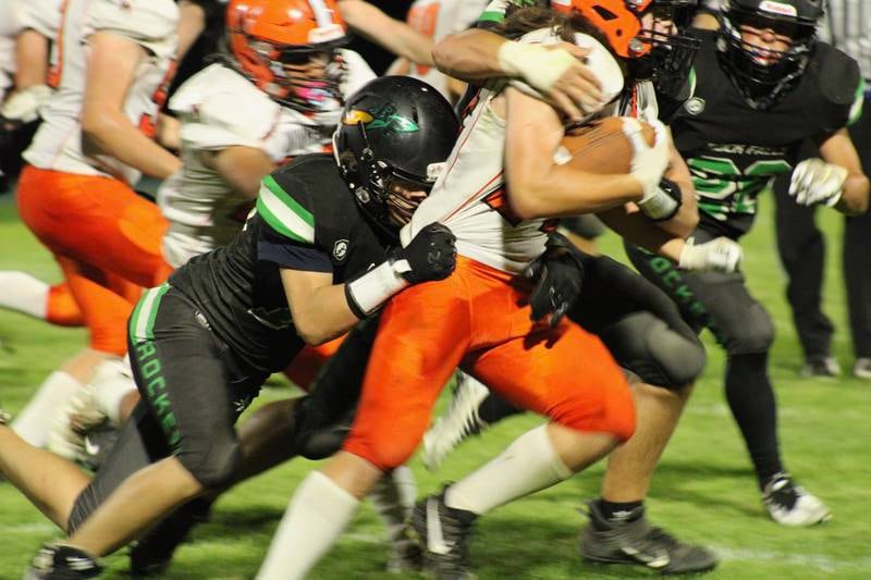 James Schmitt (57) joins  No. 15 (unlisted on the roster) join in a tackle on the Winnebago ball carrier on Friday in Rock Falls.