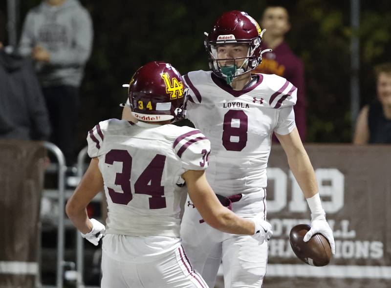 Loyola's Gabe Brooks (8) is congratulated by Drew MacPherson (34) after scoring a touchdown during the varsity football game between Loyola Academy and Mt. Carmel high school on Friday, Oct. 25, 2024 in Chicago.