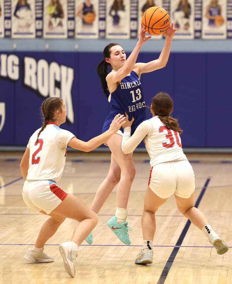 Hinckley-Big Rock's Mia Cotton passes the ball over Marian Central's Addie Leitzen (left) and Marian Central's Julia Dovidio Monday, Feb. 16, 2026, during their regional semifinal game at Hinckley-Big Rock High School.