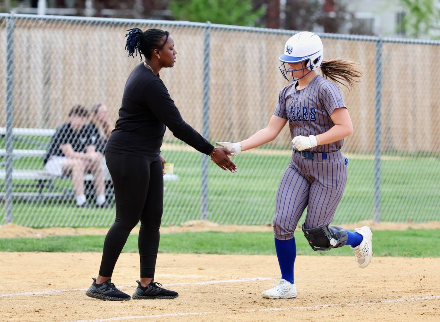 Princeton's Avah Oertel gets a glad hand from coach Jhavon Hayes after hitting a homer Tuesday against Newman. PHS won 8-2.