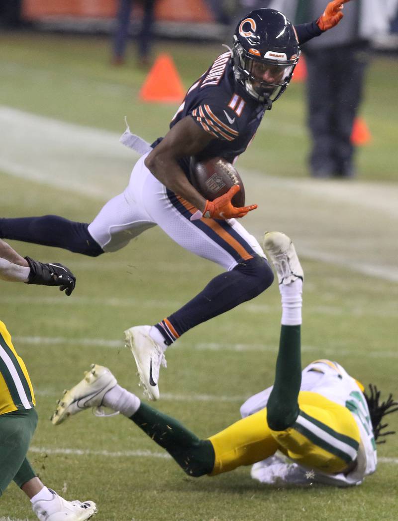 Chicago Bears wide receiver Darnell Mooney (11) jumps over Green Bay Packers cornerback Kevin King (20) during their game Sunday at Soldier Field in Chicago.