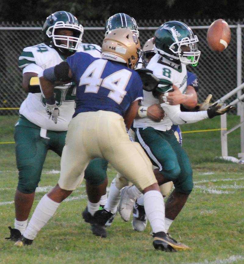 Marquette’s Alex Schaefer and Marcus Baker team up to cause a fumble by Madison’s Terry Hinds in the 1st quarter Friday at Marquette.