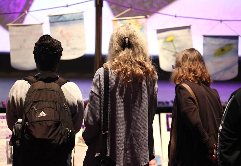 Attendees look at some of the artwork and displays Monday, Oct. 7, 2024, during the annual Safe Passage Domestic Violence Candlelight Vigil and Survivor Speak-Out inside the Egyptian Theatre in downtown DeKalb.