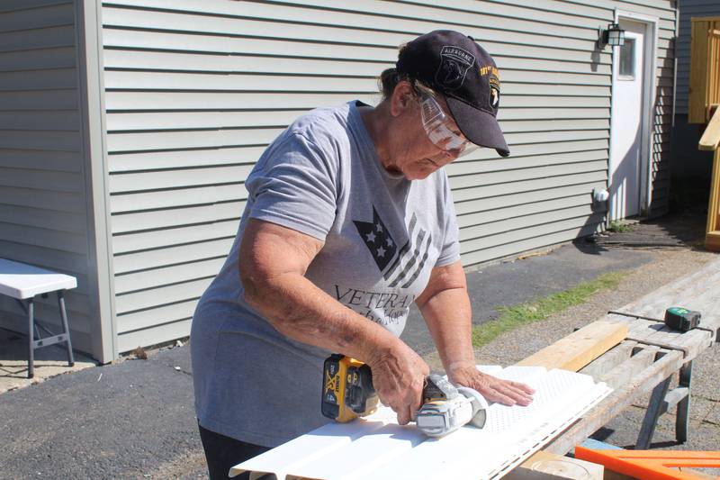 Army veteran Robin Waltrip works on the new siding to repair her home with the help of Habitat for Humanity of McHenry County.