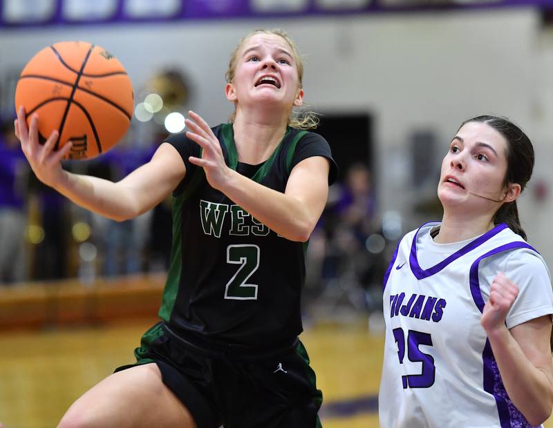 Glenbard West’s Katie Meehan (2) lays the ball up as Downers Grove North’s Caitlin Sandridge defends during a game on January 17, 2026 at Downers Grove North High School in Downers Grove .