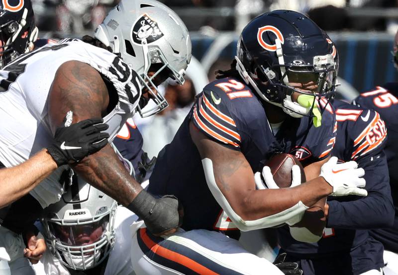 Chicago Bears running back D'Onta Foreman breaks through the Las Vegas Raiders defensive line for a gain during their game Sunday, Oct. 22, 2023, at Soldier Field in Chicago.