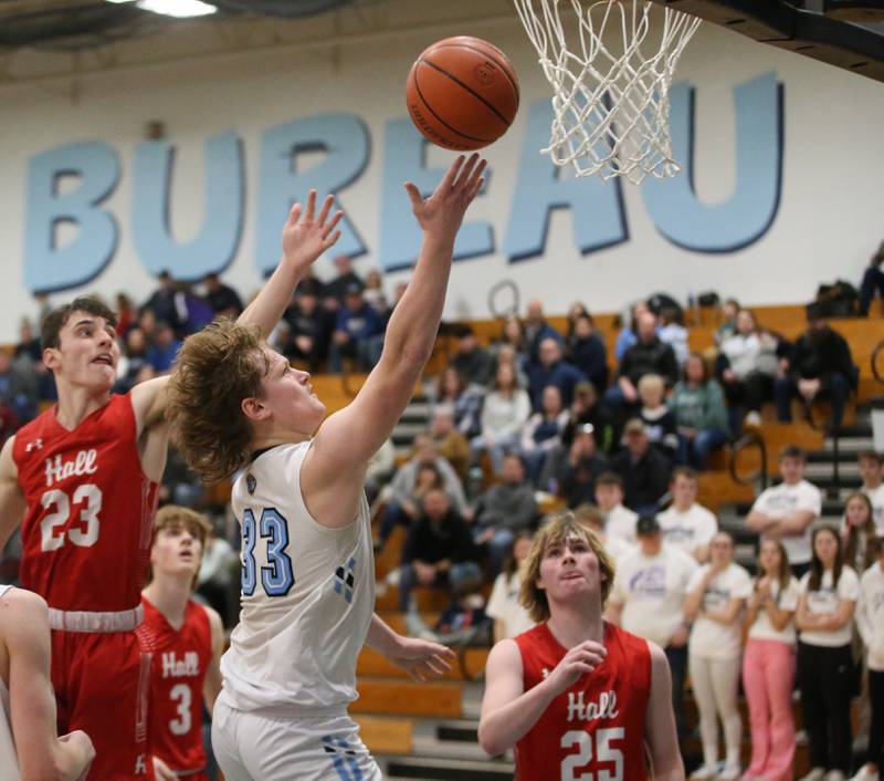 Bureau Valley's Elijah Endress eyes the hoop while running in the lane past Hall's Braden Curran and Wyatt West on Friday, Jan. 19, 2024 at Bureau Valley High School.