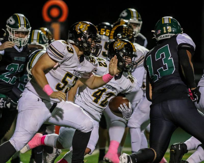 Joliet West's Gavin Garcia (42) runs up the middle with blocking help during football game between Joliet West at Plainfield Central.   Oct 20, 2023.