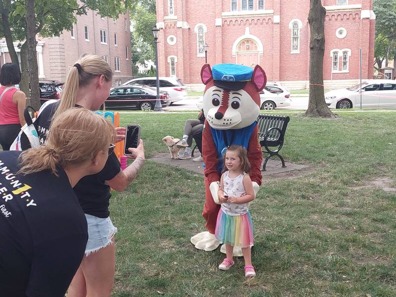 Harper Knott, of Ottawa, gets her photo taken with Chase the PAW Patrol dog on Wednesday, Aug. 2, 2023. The Ottawa Police Department organized Chase's visit to Welcomeburger.