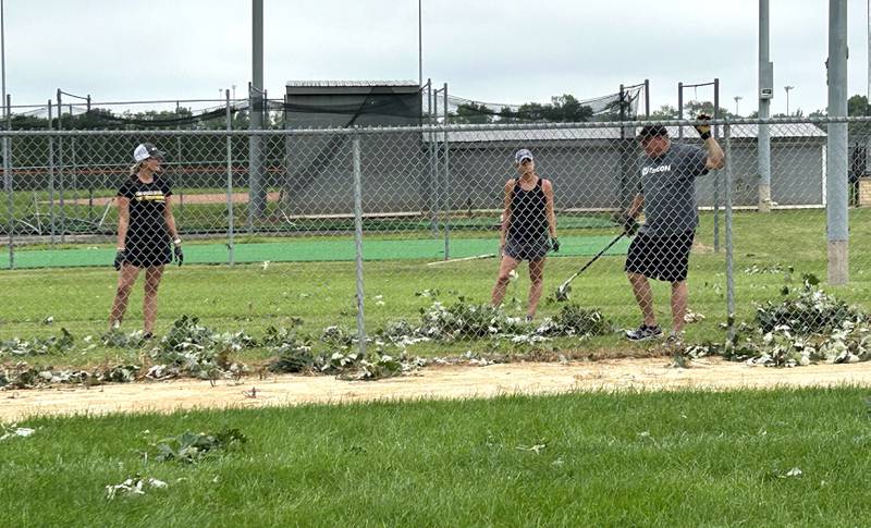 Byron School District officials Felcia Fuller, Janelle Smith, and Steve Stewart were out picking up debris on Tuesday, July 16, 2024 from Byron High School's softball field following Monday's storm.