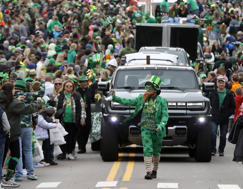 David Mulick, dressed as a Leprechaunwaves to the crown during the McHenry ShamROCKS the Fox Festival Parade on Saturday, March 16, 2024.
