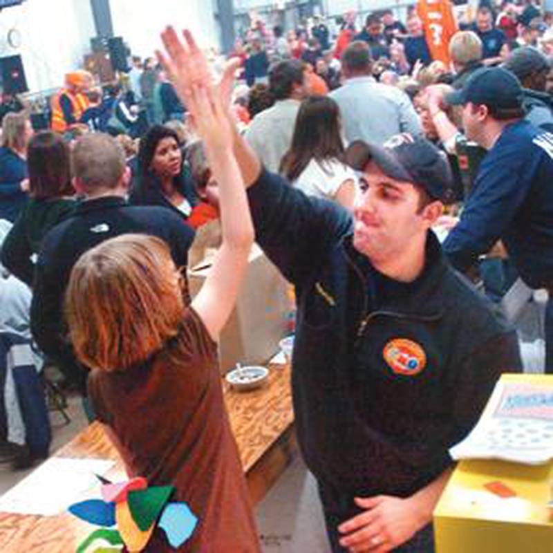 "You're the boss," North Aurora firefighter John Nalbandian says to Maddie Bozik, giving her a high-five for a job well done manning the popcorn machine Friday. The 8-year-old fire chief's daughter dressed as a turkey for the packed annual turkey raffle sponsored by the North Aurora Firefighters Association. (Kendra Helmer photo)