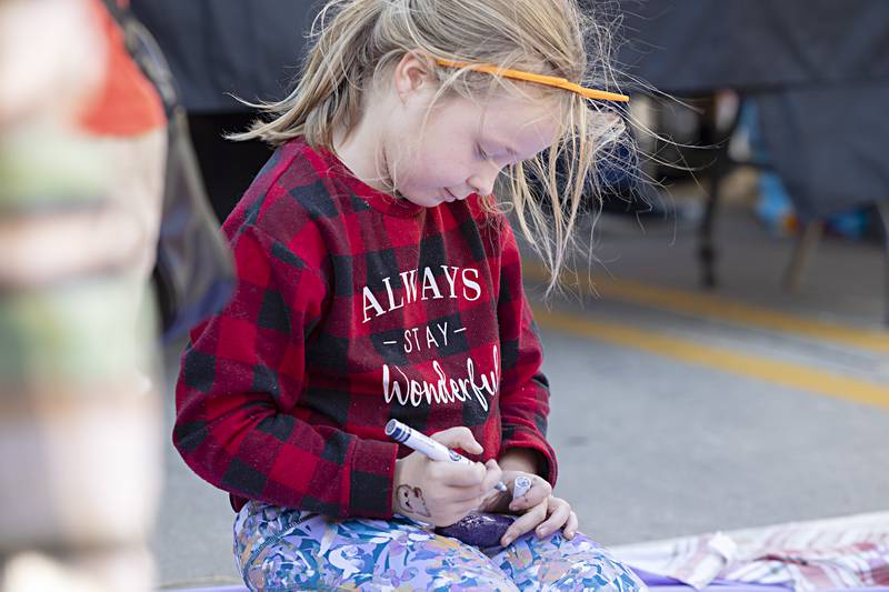 Madeline Mangrum, 7, of Dixon paints up an inspirational rock Saturday, Oct. 21, 2023 as an activity by Sauk Valley Recovery at Dixon’s Scarecrow Fest.
