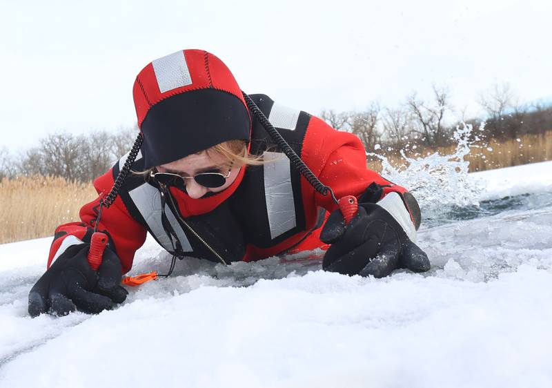 Utica firefighter Holly Brown climbs out of an ice hole during an ice-rescue training drill on a private pond on Sunday, Feb. 1, 2026 south of Utica.