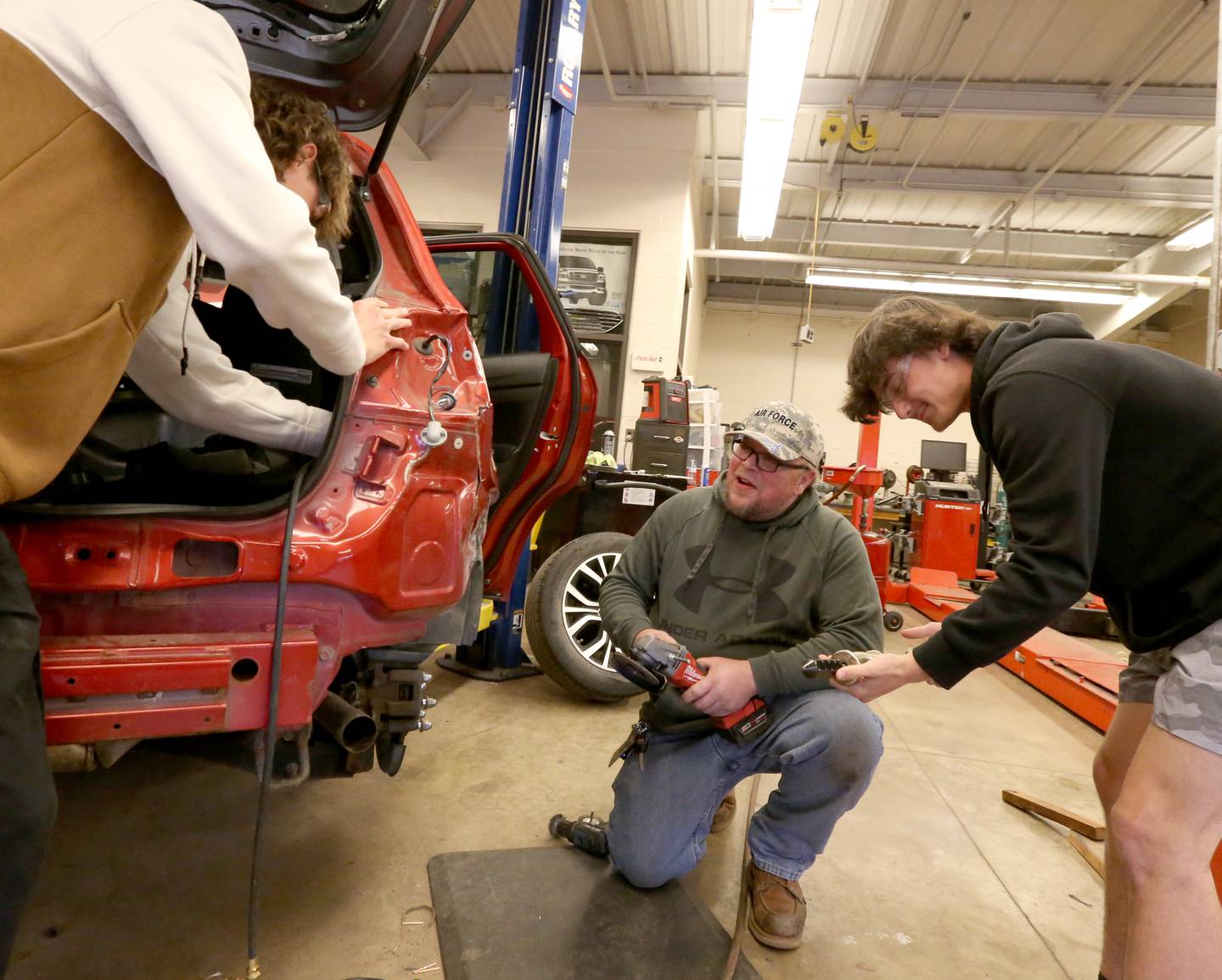 John Hladovack, auto mechanic instructor teaches students Reilly how to work on a vehicle on Monday, May 1, 2023 at Ottawa High School.