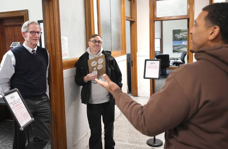 John Walker (right) talks to DeKalb City Manager Bill Nicklas (left) and Ward 5 alderman Scott McAdams Monday, Dec. 12, 2022, at City Hall. Walker who is running for Ward 7 alderman, and McAdams, who is running for re-election in Ward 5, were waiting in line to be among the first to file to get their names on the ballot for the April election. Candidate filing began Monday at 8:30 a.m. at City Hall.