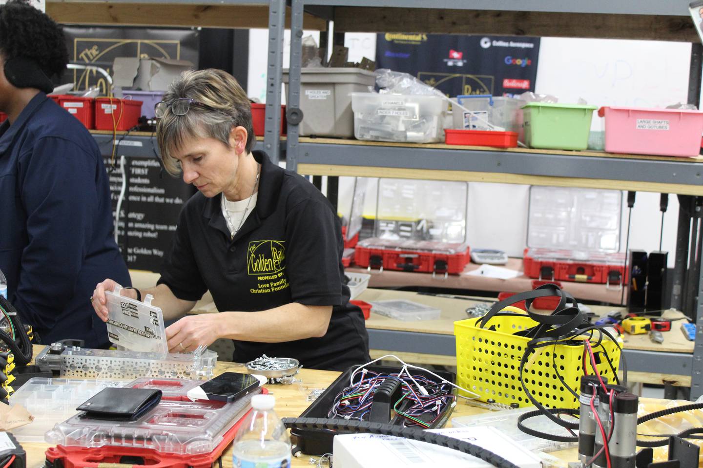 Coach of the McHenry County STEM team The Golden Ration Tammy Massey digs through tools for last minute tweaks on the team's robot before heading to the international competition in Texas.