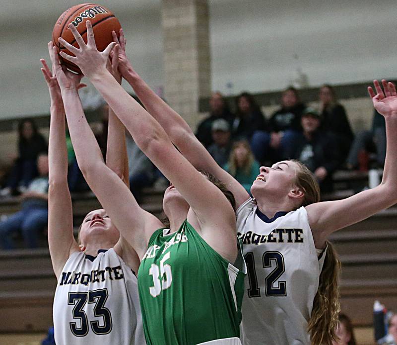 Seneca's Tessa Krull, (center) Marquette's Keely Nelson and teammate Lily Craig fight over a rebound in Bader Gym on Monday, Jan. 23, 2023 at Marquette High School.