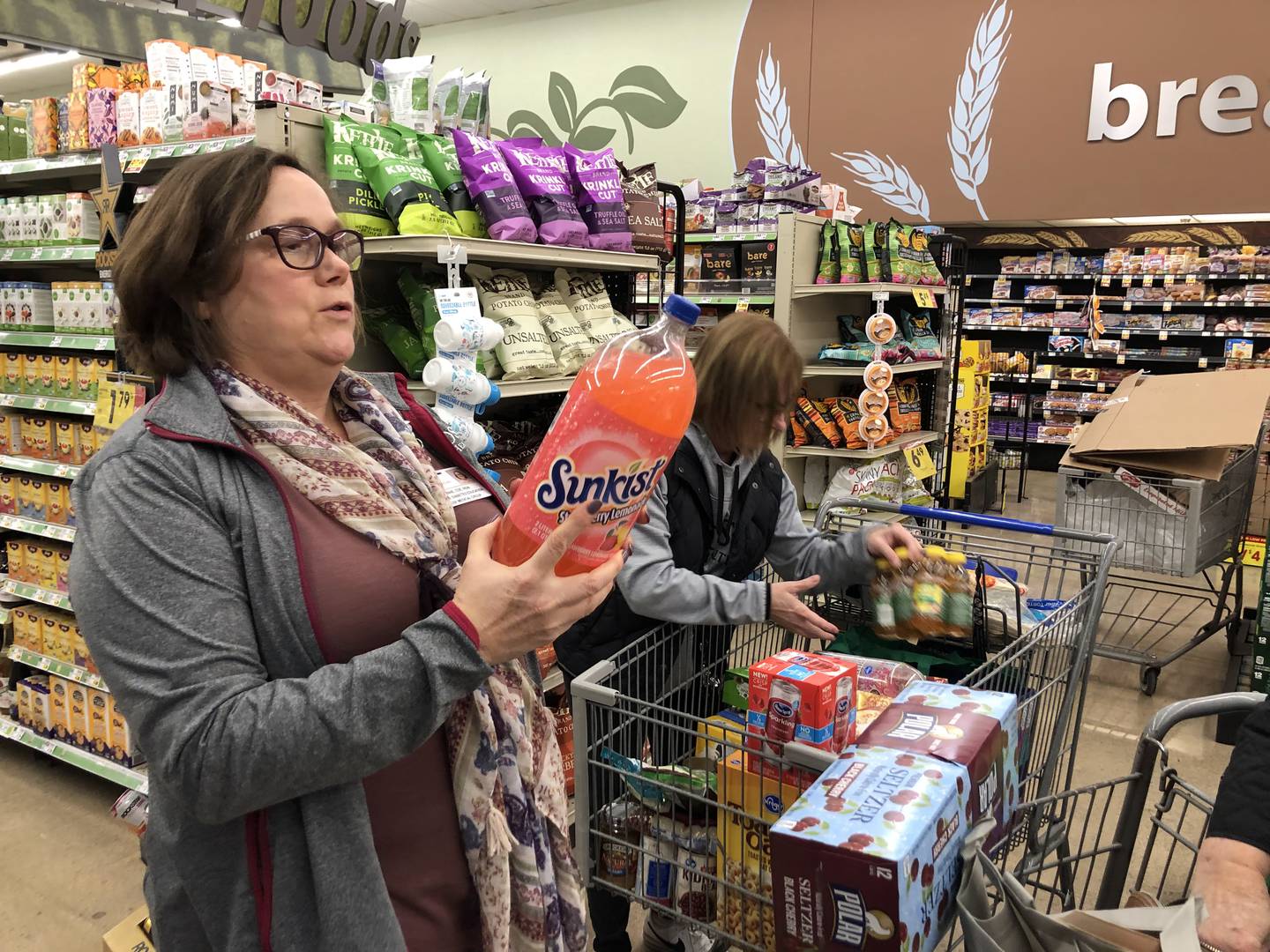 Anne Lauterjung reads aloud a soft drink label during the OSF grocery store tour at Kroger in Ottawa on Sunday, Nov. 13, 2022.
