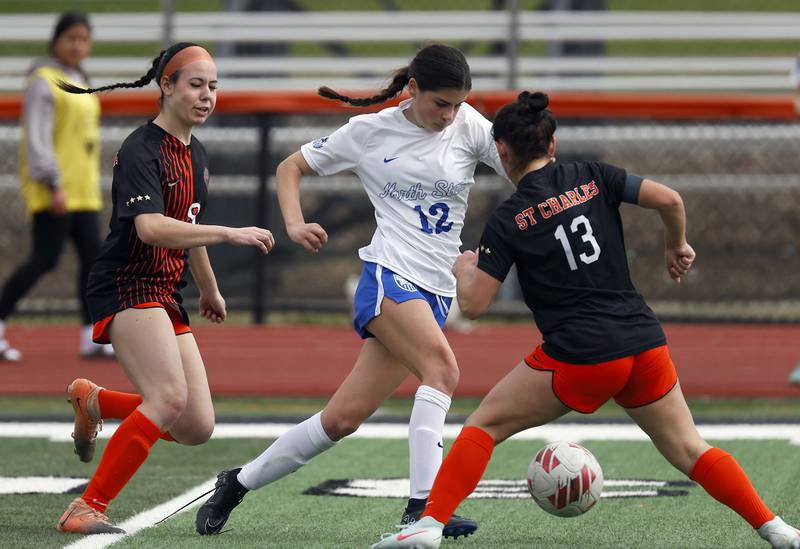 St. Charles North's Madi Shanahan (12) splits two St. Charles East players during the championship game of the Rose Augsburg Drach Invitational Saturday, March 29, 2025 in St. Charles Ill.