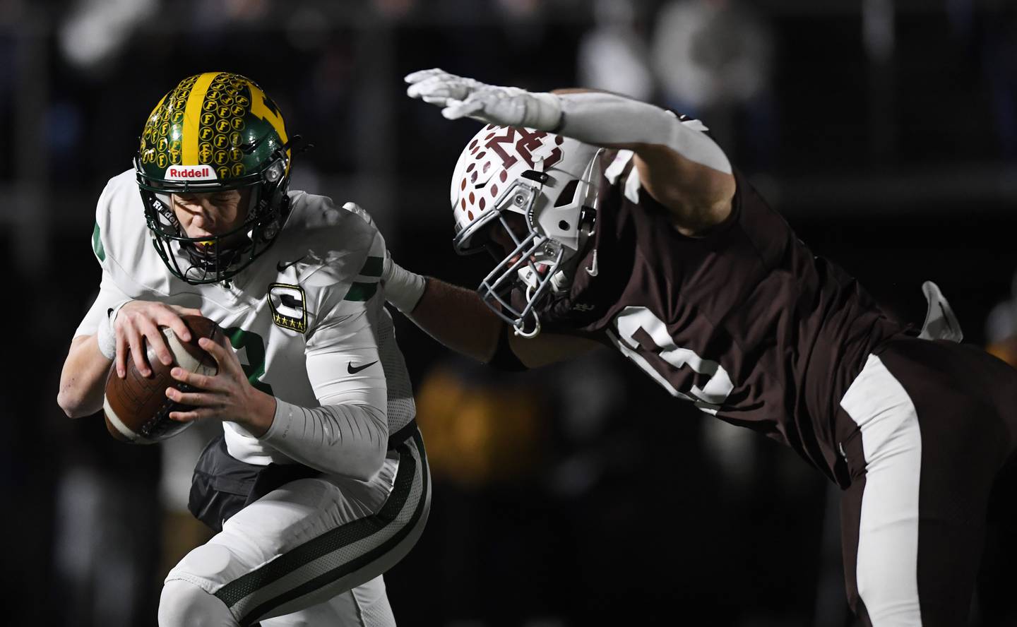 Fremd quarterback Johnny O'Brien, left, gets sacked by Mount Carmel's Dean Kemph during the IHSA Class 8A football semifinal game on Saturday, Nov. 22, 2025 in Chicago.