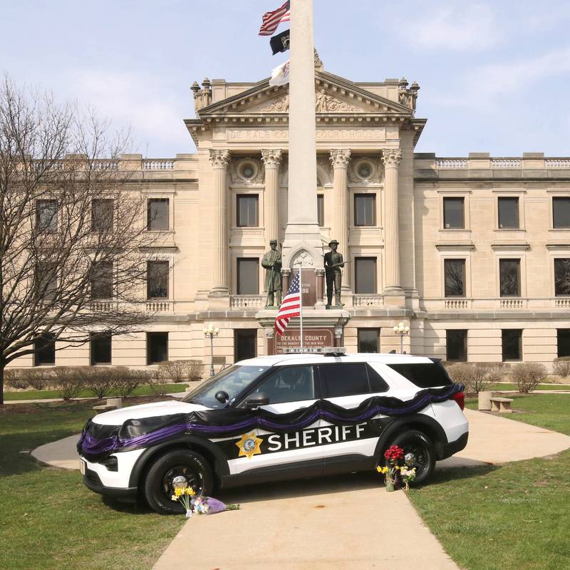 A DeKalb County Sheriff’s vehicle with black and purple bunting sits in front of the DeKalb County Courthouse in Sycamore Friday, March 29, 2024, as a memorial to DeKalb County Sheriff’s Deputy Christina Musil, 35, who died in a crash while working a shift Thursday night.