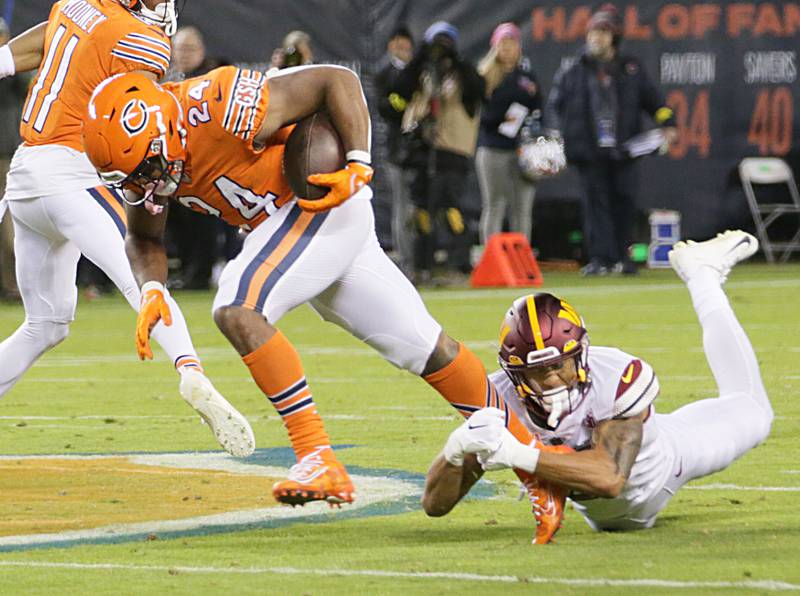 Chicago Bears running back Khalil Herbert (24) takes off on a run after escaping a tackle from Washington Commanders corner back Benjamin St-Juste (25) on Thursday, Oct. 13, 2022 at Soldier Field.