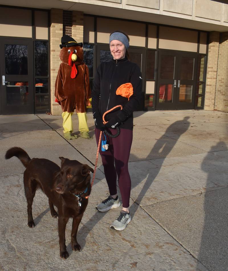The first female runner to cross the finish line at Morrison's Turkey Trot Saturday, Nov. 30, 2024 was Kristy Schisler. Here, she poses with Brownie who also competed in the race.