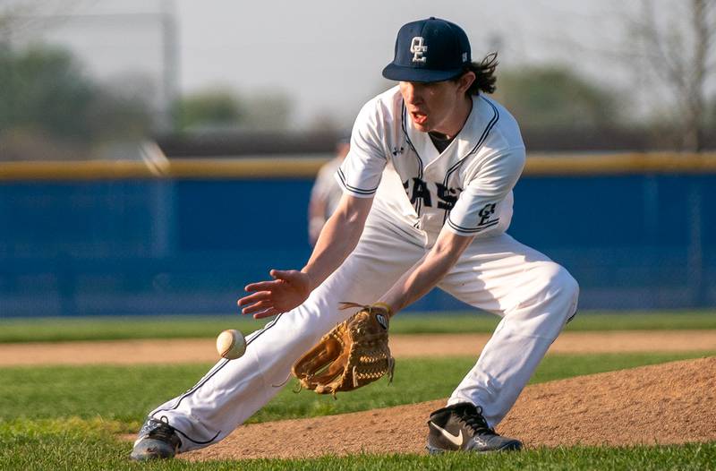 Oswego East's Patrick Flynn (12) fields a grounder against Oswego for an out during a baseball game at Oswego East High School on Tuesday, May 10, 2022.