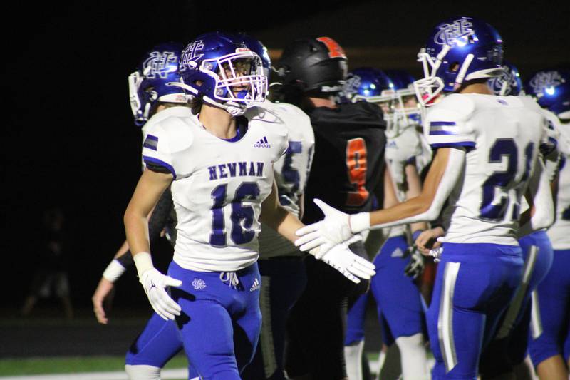 Newman's Ayden Batten (16) accepts a teammate's congratulations after his 51-yard touchdown on a pass play on the team's first possession of the game Friday, Oct. 21, 2022, in Kewanee.
