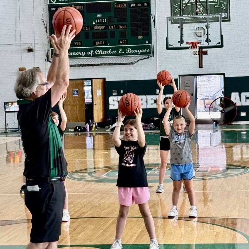 St. Bede coach Tom Ptak works on ball-handling skills with campers in the Lady Bruins Basketball Camp. He has returned as the new varsity coach after serving as interim head coach in 2021-22 and previously as an assistant.