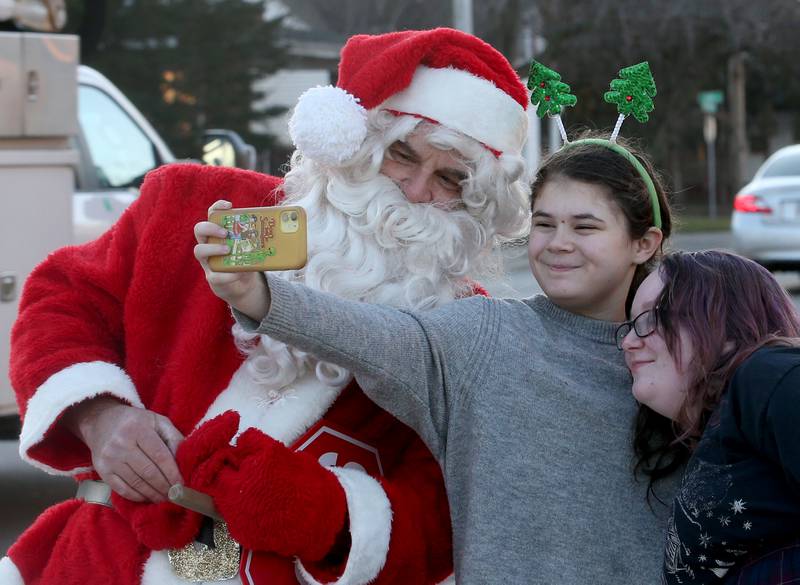 Lincoln Junior High School students Delia Sellers and Elyssa Thomas take a "selfie" with Santa Claus at Lincoln Junior High School in La Salle. Santa came to the school to assist students as the crossing guard for the morning.