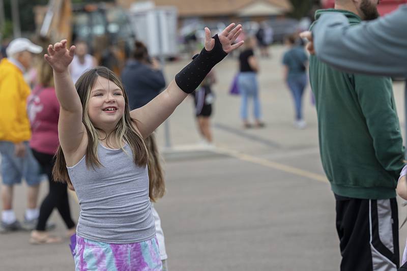 Naveah Allen, 8, warms up with some calisthenics Tuesday, Aug. 6, 2024 during National Night Out in Dixon. The Dixon Family YMCA’s fitness director Katie Matteson was on scene offering some healthy exercises.