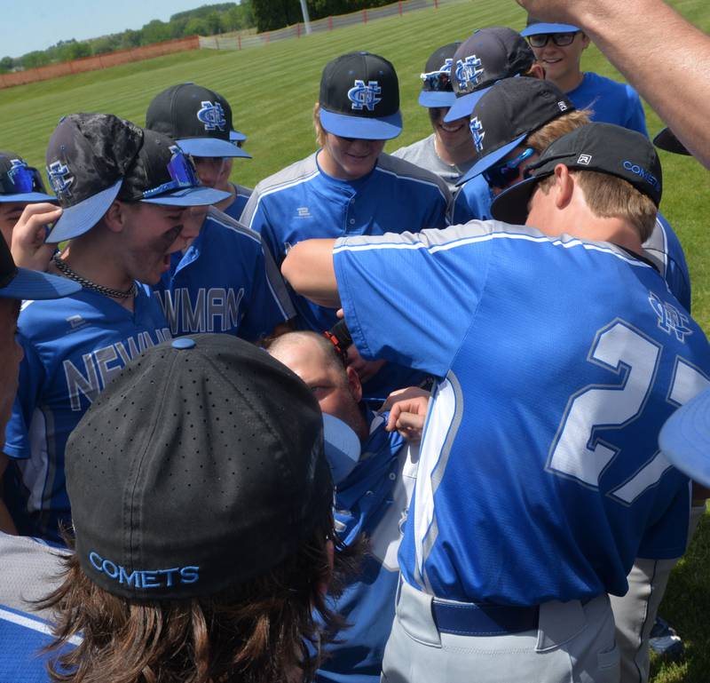 Newman players huddle around John Kutz as they shave a strip of his hair after beating Dakota 10-7 at the 1A Pearl City Sectional on Saturday, May 27. The shaving of his hair has been a tradition for the Comets after each of their wins since the regional.